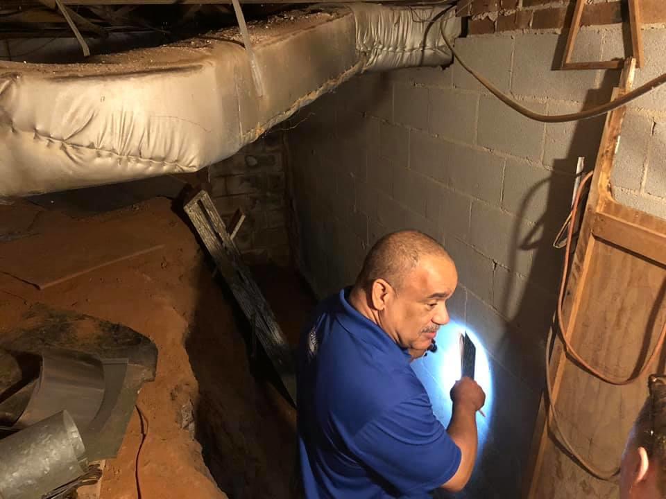 David inspecting how water is coming into the crawl space and basement to offer a solution.